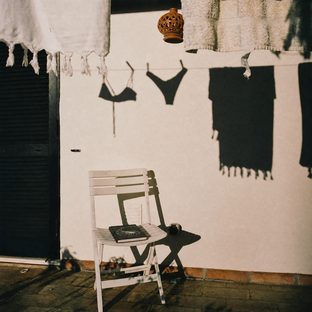 journal on a chair next to clothes air drying 
