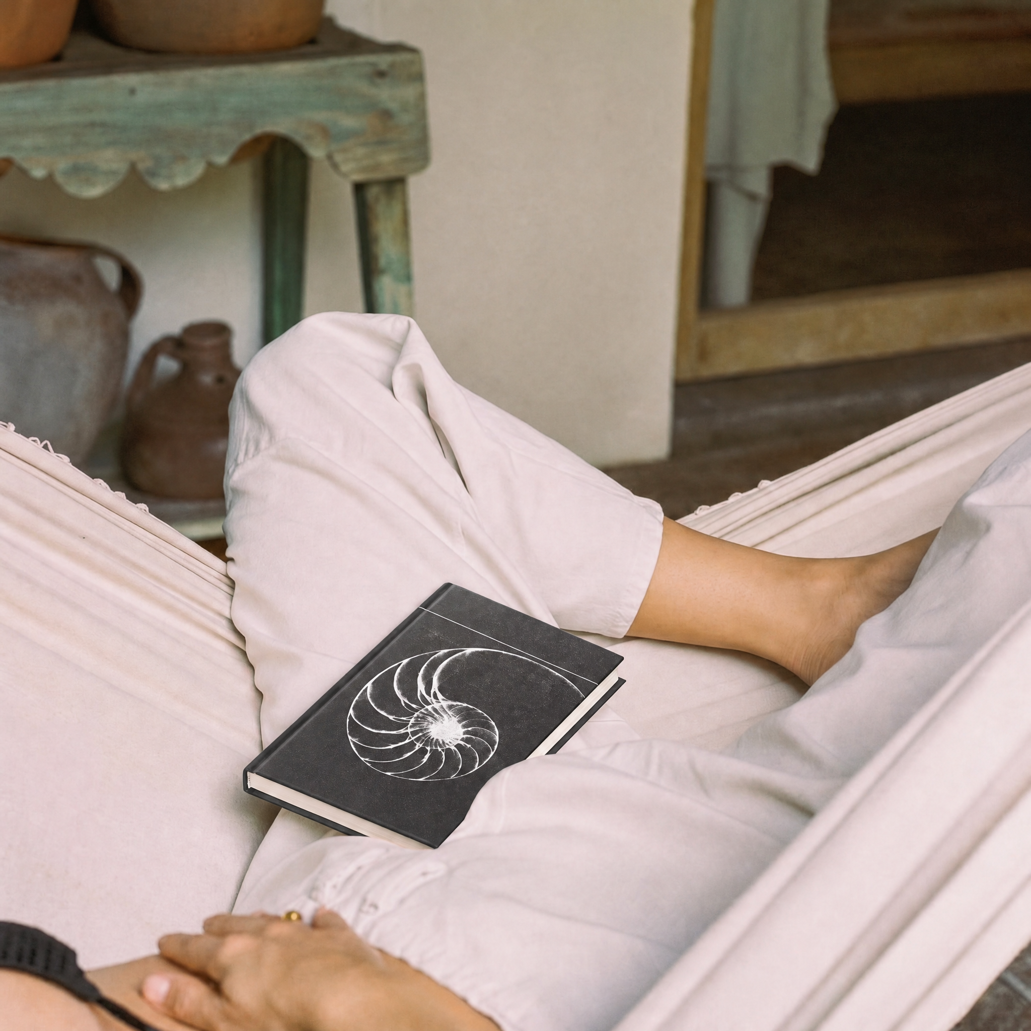 girl laying in a hammock with a journal 