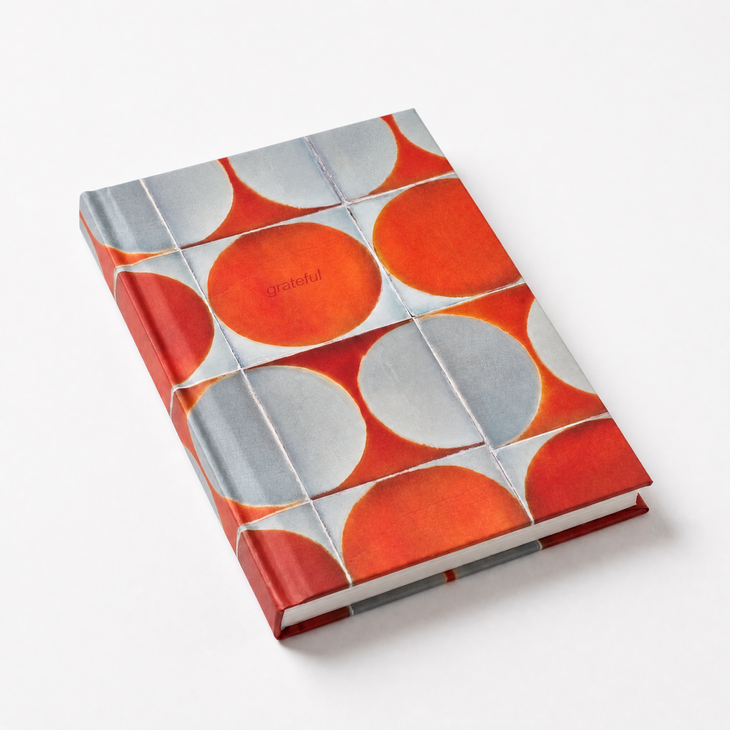 Notebook with orange and gray circular pattern on a white background