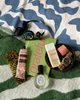 Various items including a bottle, hairbrush, and book on a patterned surface