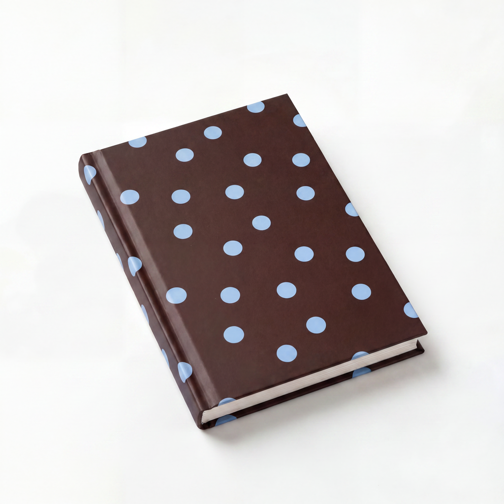Brown notebook with blue polka dots on a white background