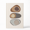 A hardcover notebook with a cream-colored cover featuring a minimalist graphic of three stacked abstract stone-like shapes in earthy brown, gray, and beige tones, set against a clean white background.