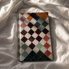 Notebook with a multicolored checkered pattern on a white fabric background
